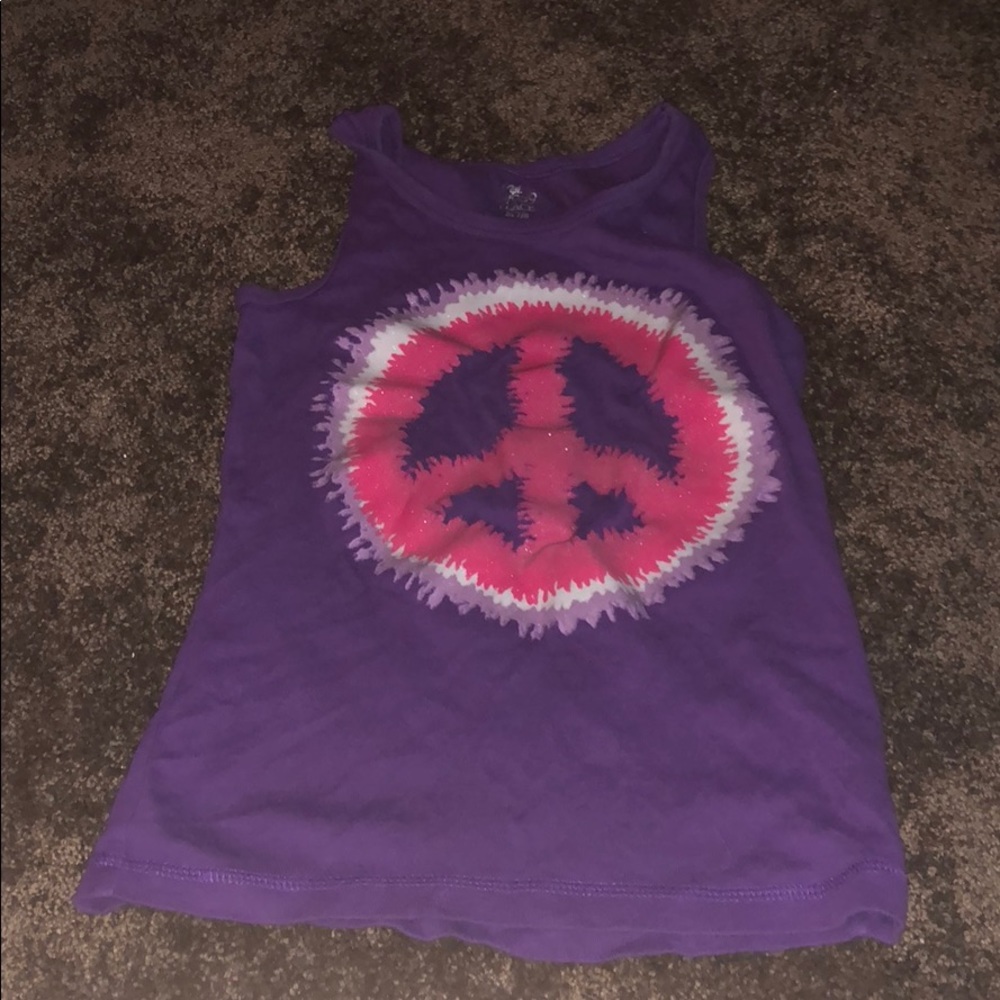 A purple shirt with a piece sign that is tie died